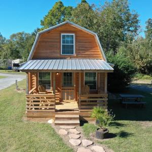 una baita di tronchi con portico e finestra di Wanee Lake Golf & RV Resort ad Ashburn
