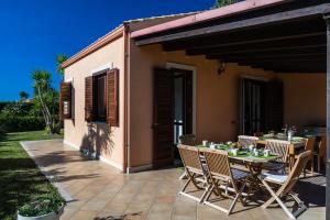 a table and chairs sitting on a patio at Villa Scilla - Pool & Garden in Plaia Grande