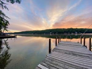 ein Dock auf einem Wasserkörper mit Sonnenuntergang in der Unterkunft Sunrise Cottage in Alton Bay