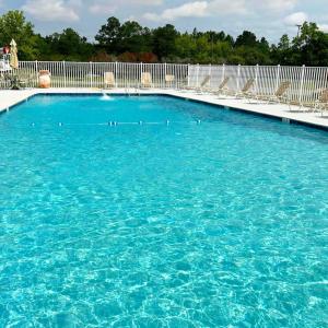 una grande piscina di acqua blu con sedie di Wanee Lake Golf & RV Resort ad Ashburn