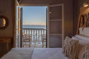 普拉坦亚斯Archontiko Seaside Hotel的一间带床的卧室和一个带桌子的阳台