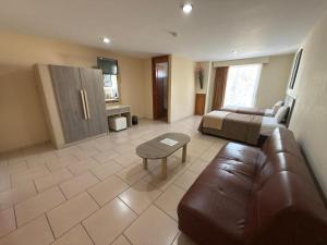 een woonkamer met een bank en een bed bij Hotel Ciprés Puebla in La Concepción