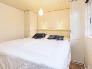 a bedroom with a white bed with two pillows on it at 4 person holiday home in Karrebæksminde in Karrebæksminde