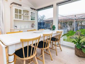 a kitchen with a large window and a table with chairs at 4 person holiday home in Karrebæksminde in Karrebæksminde +32 photos