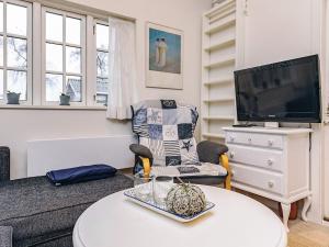 a living room with a couch and a tv at 4 person holiday home in Karrebæksminde in Karrebæksminde