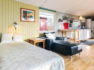 a bedroom with a bed and a couch and a chair at 4 person holiday home in Vordingborg-By Traum in Vordingborg