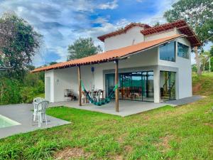 una piccola casa bianca con un ampio patio di RANCHO NATURE piscina e hidromassagem no LAGO CORUMBÁ 4 ALEXANIA a Alexânia