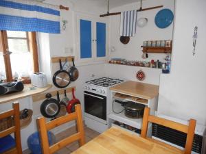 a kitchen with a stove and a counter with a table at Chalupa u Evy in Smržovka