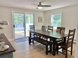 a dining room with a wooden table and chairs at Sunrise Bay in Alton Bay