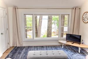 ein Wohnzimmer mit 2 Fenstern und einem Sofa in der Unterkunft Sunrise Cottage in Alton Bay