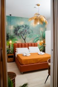 那不勒斯Four Points Suites的一间卧室配有一张带棕榈树壁画的橙色床