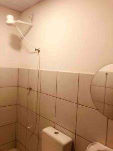 a bathroom with a shower head and a toilet at Apartamento Caminho da Praia in Parnaíba