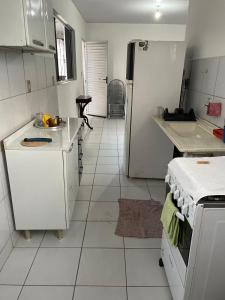 a kitchen with white cabinets and a refrigerator at Apartamento Caminho da Praia in Parnaíba