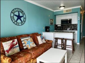 ein Wohnzimmer mit einer Couch und einer Uhr an der Wand in der Unterkunft Ocean Views steps to beach - Shoreline Stays 29 in Galveston