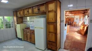 セーハ・ネグラにあるA Casa de Pedraの木製のキャビネットと白い冷蔵庫を備えたキッチン