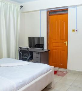 a bedroom with a desk with a computer and a door at Luxury Two Bedroom Master & Suite Apartment in Nairobi