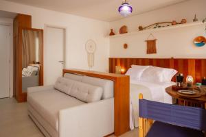 a bedroom with a bed and a couch at Estilo Itacaré - By Férias Itacaré in Itacaré