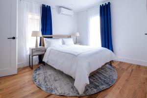 a bedroom with a bed with blue curtains and a rug at 323-2 Spacious 2BR Williamsburg in Brooklyn