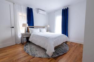 a bedroom with a bed with blue curtains and a rug at 323-2 Spacious 2BR Williamsburg in Brooklyn