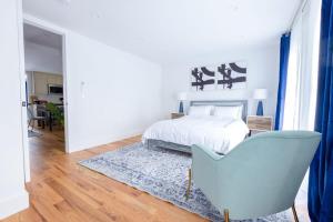 a white bedroom with a bed and a blue chair at 323-2 Spacious 2BR Williamsburg in Brooklyn +52 photos