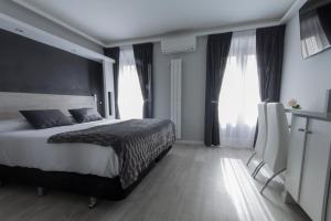 sypialnia z dużym łóżkiem i dwoma oknami w obiekcie Hostal Overnight Madrid w Madrycie