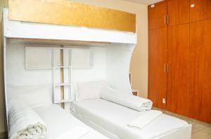 a white bunk bed with a white couch in a room at Luxury Two Bedroom Master & Suite Apartment in Nairobi