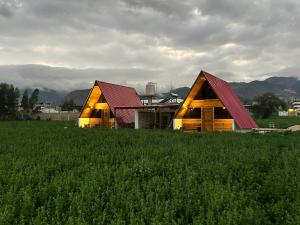 a barn with a red roof in a field of grass at La Encantad Cabañas - Amanecer in Cajamarca
