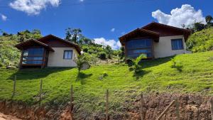 a house on a hill with green grass at Chalés nas Montanhas in Domingos Martins