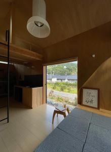 a bedroom with a bed and a large window at タイニーハウスTｈ01 in Higashihiroshima