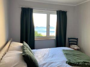 a bedroom with a bed and a large window at Tigh en Leigh in Shieldaig