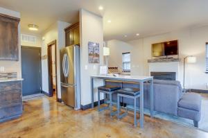 a kitchen with a refrigerator and a table and a couch at Urban Roundabout in Bend