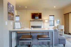 a kitchen and living room with a table and two stools at Urban Roundabout in Bend +18 photos