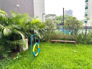 a playground in the grass next to a bench at 1201 - Rentaqui Moema Comfort Windon in Sao Paulo