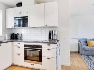 a kitchen with white cabinets and a stove top oven at Læsø Essence A Taste of Island Life in Læsø