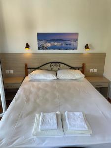 a large white bed with two towels on it at Villa Elpiniki in Troulos