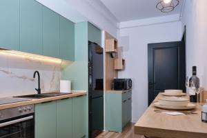 a kitchen with blue cabinets and a counter top at Chill & Cozy in Valea Lupului