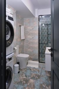 a bathroom with a toilet and a washing machine at Chill & Cozy in Valea Lupului +9 photos