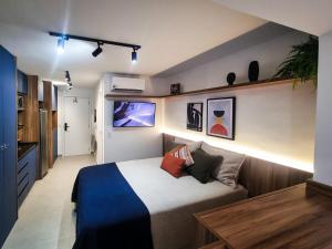 um quarto com uma cama e uma TV na parede em Raízes Tucuruvi Studios em São Paulo mais 128 fotografias