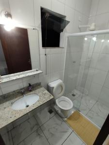 a bathroom with a toilet and a sink and a shower at Suíte Privativa in Paraty