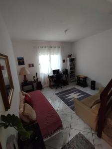 a living room with a couch and a table at Suíte Privativa in Paraty