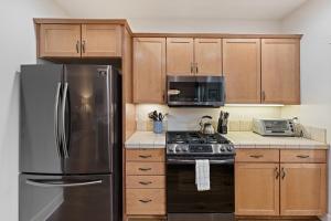 a kitchen with wooden cabinets and a stainless steel refrigerator at Tranquility on the Bluffs in Bend