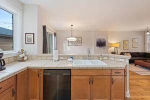 a kitchen with a sink and a living room at Tranquility on the Bluffs in Bend