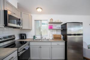 una cucina con mobili bianchi e un frigorifero in acciaio inossidabile di Picture Perfect at Sam's Beachcomber a Lake Havasu City Altre 34 foto