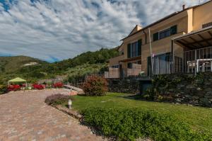 a building with a brick driveway next to a mountain at Oroverde in Bergeggi