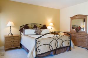 a bedroom with a large bed and a mirror at Villa #5 at Broken Top in Bend +12 photos