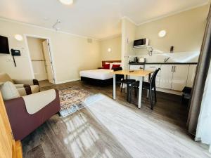 a small room with a bed and a table in it at Colonial City Motel in Hamilton