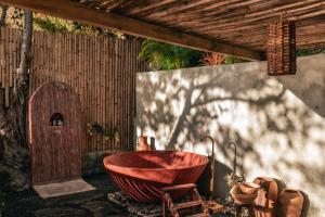 a bathroom with a red bath tub sitting under a roof at Baba Yaga Atitlan in San Marcos La Laguna +35 photos