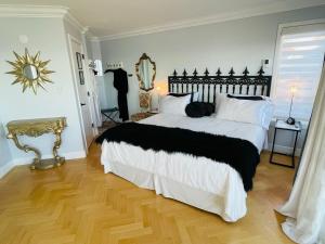 a bedroom with a black and white bed and a mirror at Donna's Bed & Breakfast in White Rock