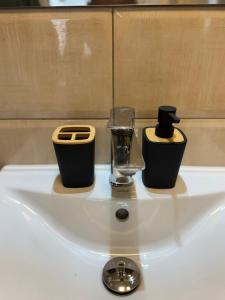 due candele poggiate su un lavandino bianco di Mother Teresa Apartment a Skopje Altre 33 foto