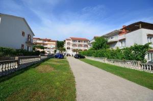 a walkway leading to a group of houses at Apartments and rooms with parking space Lopar, Rab - 23825 in Rab